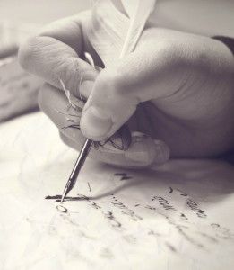 Людина пише пером на папері